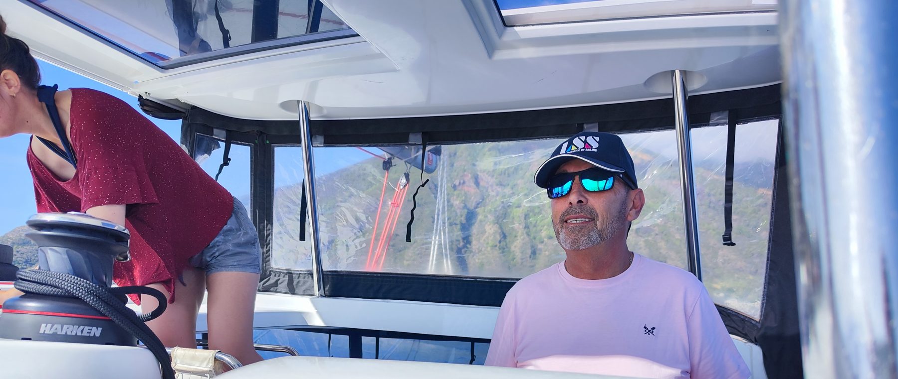 The skipper at the wheel under bimini